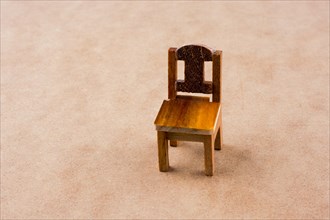 Brown color wooden toy chair on colorful background