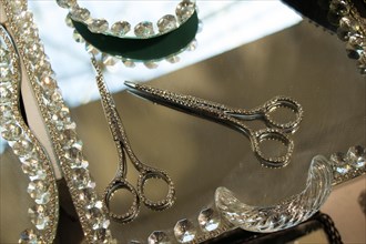 Metal scissors with diamonds on it on a mirror