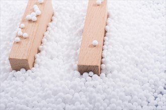 Wooden blocks in White polystyrene foam balls as background