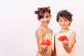 Caucasian children eating a watermelon in the summer heat