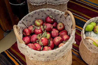 Red and green apples in straw baskets in display