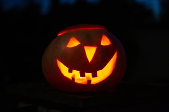 Halloween pumpkin illuminated against a dark evening sky