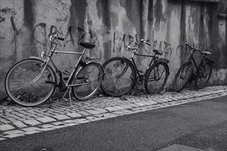 Bicycles standing in front of an old house wall