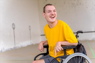 Portrait of a disabled person in a wheelchair at a Basque pelota game fronton smiling