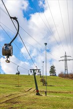 Ski lift at standstill due to lack of snow caused by climate change at the end of winter on a hill in Muensingen