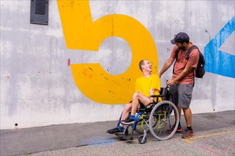 Disabled person in a wheelchair with a cement wall