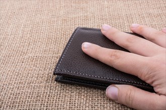 Brown leather wallet in hand saving and finance concept