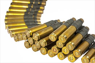 50 Caliber machine gun cartridges in ammunition belt against white background