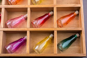 Colorful small bottles in a wooden box in the view