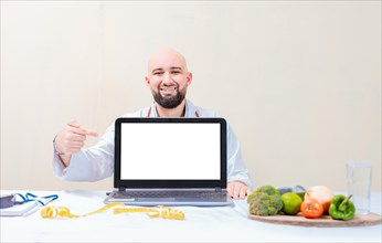 Smiling nutritionist pointing at an advertisement on the laptop