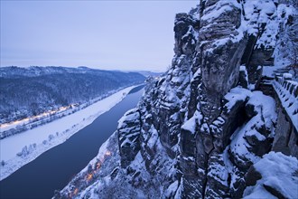 View at dusk from Bastei Bridge into the Elbe Valley with snow