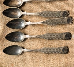 Stylish steel teaspoons on a textured background in display