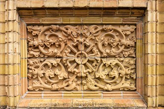 Historic architectural exterior detail with tendril ornamentation made of brick material