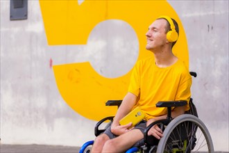 Portrait of a disabled person dressed in yellow in a wheelchair listening to music