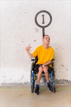 A disabled person in a wheelchair at a Basque pelota game fronton having fun