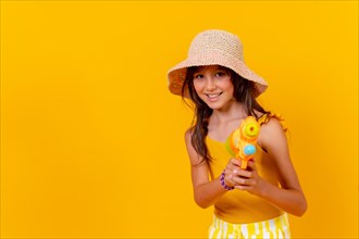 Portrait of a girl playing with a water gun on summer vacation