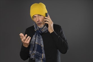 Elderly man with yellow cap on the phone