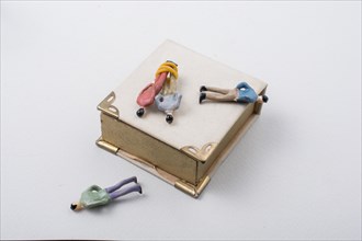 Tiny figurine of men model tied in rope beside a book