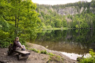 A woman sits on a bench at Feldsee