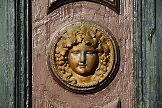 Womans head in relief on an old house door