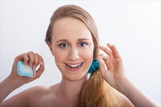 Portrait of a young woman with dental floss in her hands