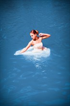 Bride stands with her dress in the water