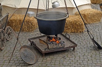 Old kettle over a fireplace at a historical festival in Gengenbach