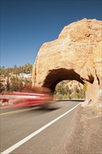 Motion blur of a vehicle going under natural stone arch