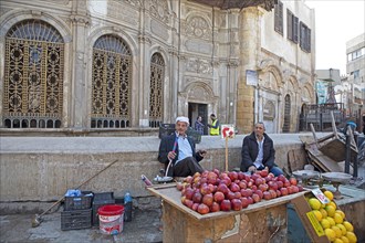 Egyptian man smoking shisha or hookah at a fruit stall