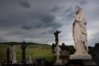Praying statue of the Virgin Mary in a cemetery