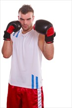 Stately muscular young man with boxing gloves and white shirt in devotional posture