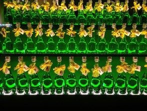 Three rows of bottles with alcoholic high-proof drink green absinthe