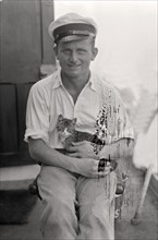 Sailor with cat in his arms on board a cargo ship