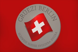 Red board with the Swiss flag and the inscription Grueezi Berlin