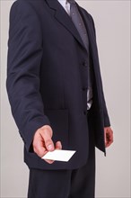 Torso view of a male businessman handing over a blank white business card with his credentials and company name