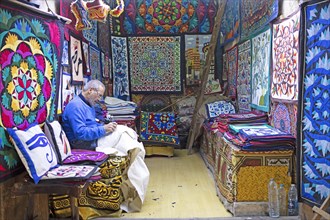 Egyptian man embroidering a cushion in a shop
