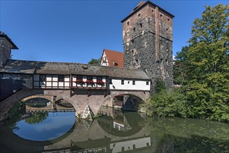 Medieval hangmans bridge and former water tower with reflection in the Pegnitz
