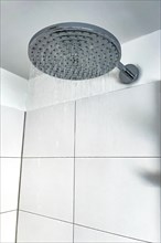 Running water from in shower with large shower head type rain shower with high water consumption