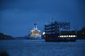 Cargo ships and cruise ship sailing at night in the Kiel Canal