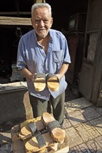 Egyptian man with traditional wooden slippers for mosque visit