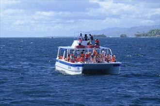 Tourists on a whale watching boat in Samana Bay