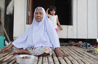 Old woman with headscarf in the Muslim village of Batu Village