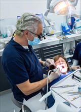 Dentist does dental prophylaxis performs dental treatment caries treatment
