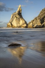 Sunset on sandy beach with rocks
