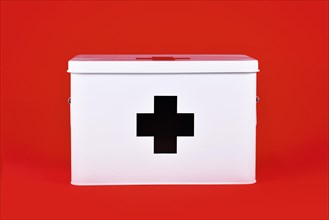 White first aid kit with black cross on red background