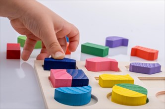 Colorful wooden pieces of a logic puzzle in hand