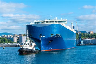 Cargo ship transporting a giant ship in the bay of Pasaia to the open sea Pasajes