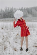 Woman in red coat with cloud on her head in the snow
