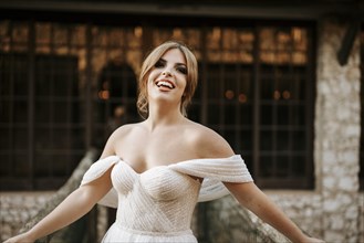 Beautiful bride portrait standing on wooden bridge with stone house behind