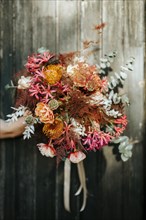 Beautiful rustic bouquet hold on wooden door background